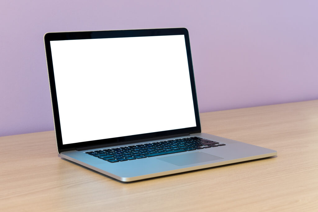 open laptop wooden table lilac wall office